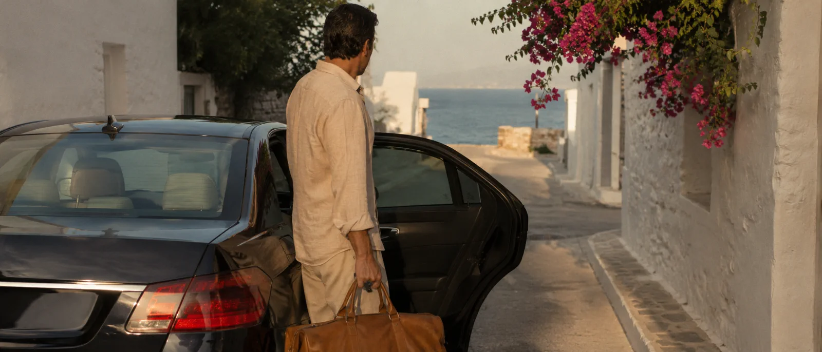 A Tripwise driver and car waiting at a villa gate on Páros